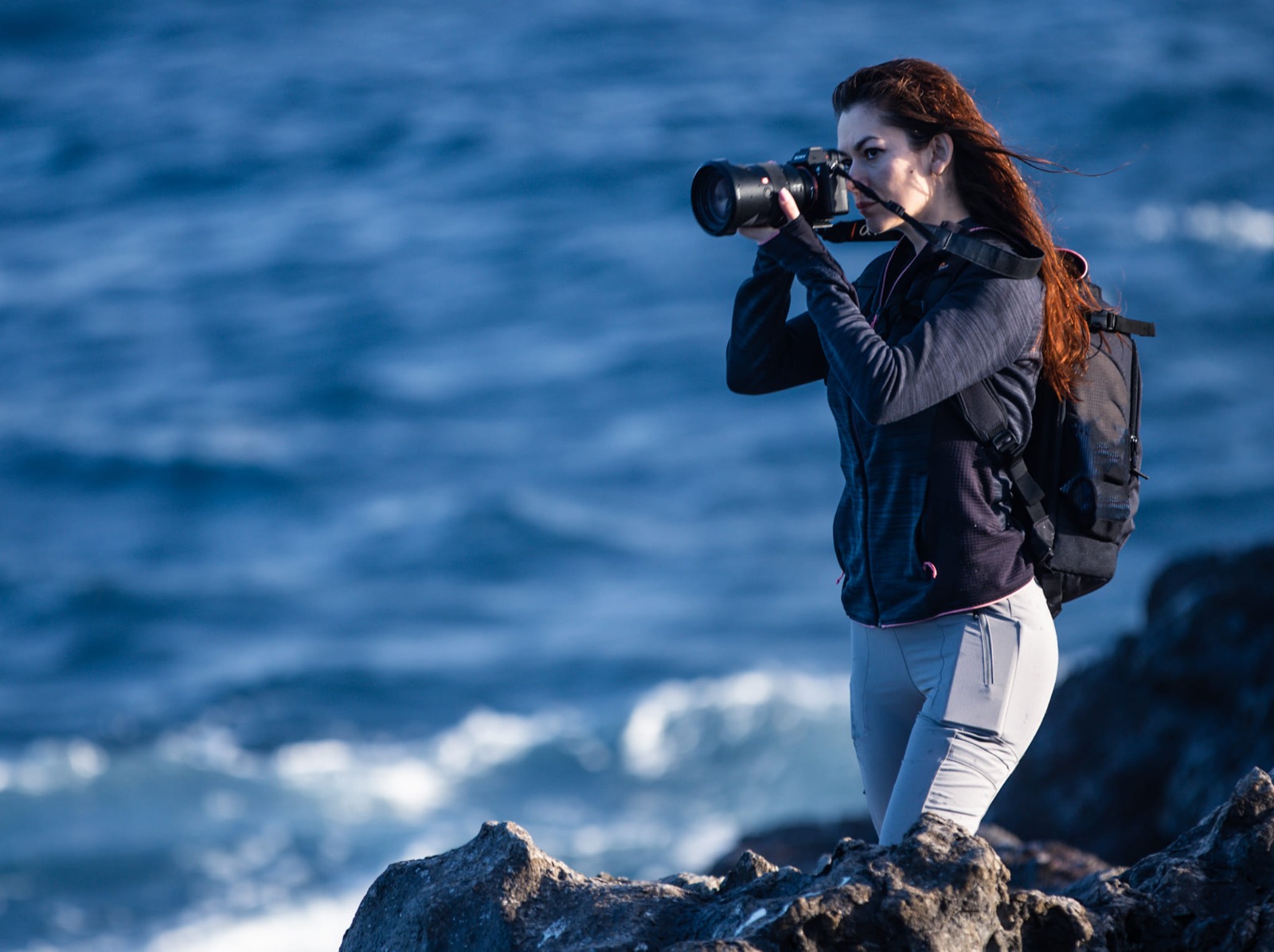 Bianca fotografiind pe stânci la malul mării